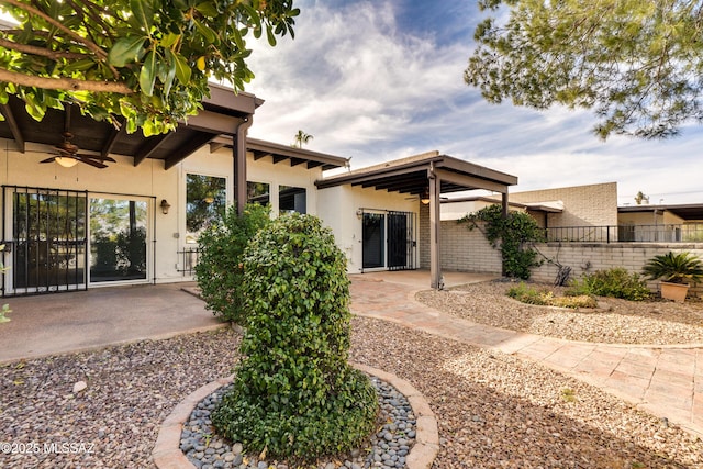 back of house featuring ceiling fan, brick siding, fence, stucco siding, and a patio area