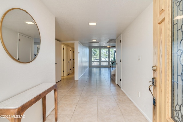 hall with light tile patterned floors and baseboards