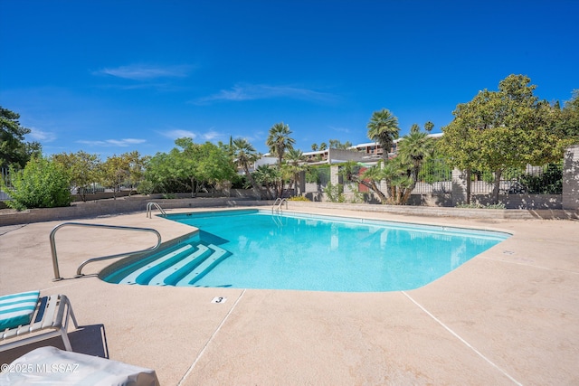 community pool featuring a patio area and fence