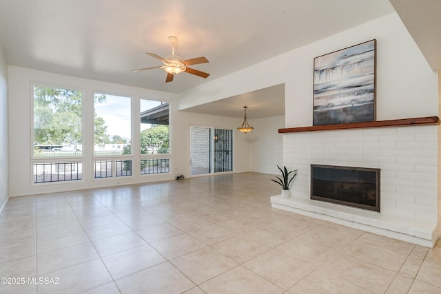 unfurnished living room with light tile patterned floors, a brick fireplace, and a ceiling fan