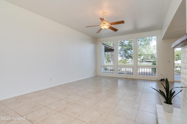 spare room with light tile patterned floors, ceiling fan, plenty of natural light, and baseboards