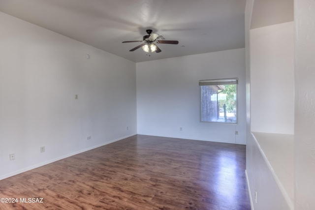 empty room with ceiling fan and dark hardwood / wood-style floors