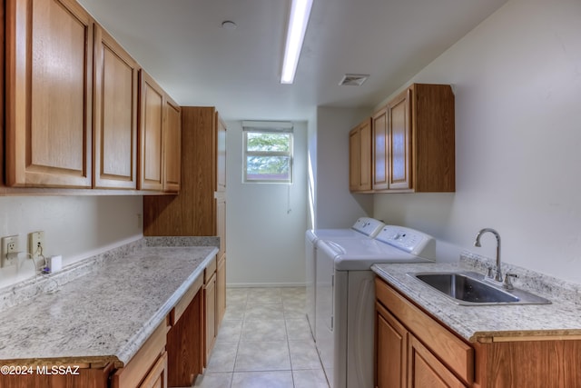 clothes washing area featuring sink, independent washer and dryer, light tile patterned floors, and cabinets