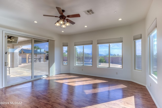 unfurnished room with ceiling fan, hardwood / wood-style flooring, and plenty of natural light