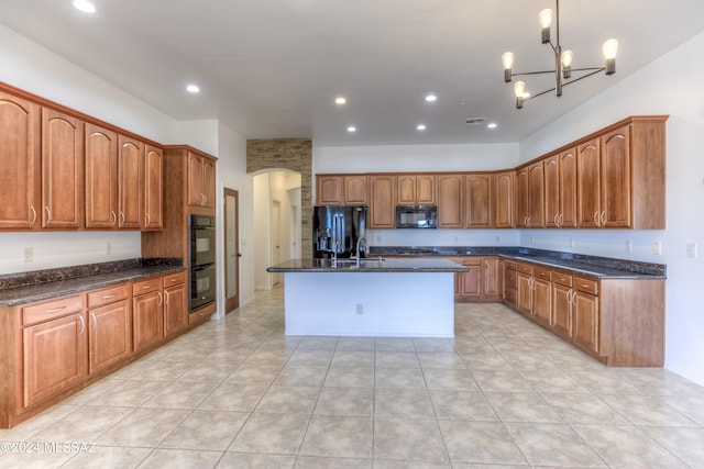 kitchen featuring hanging light fixtures, a kitchen island with sink, a chandelier, black appliances, and sink