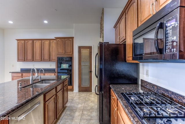 kitchen featuring light tile patterned flooring, black appliances, sink, and dark stone counters