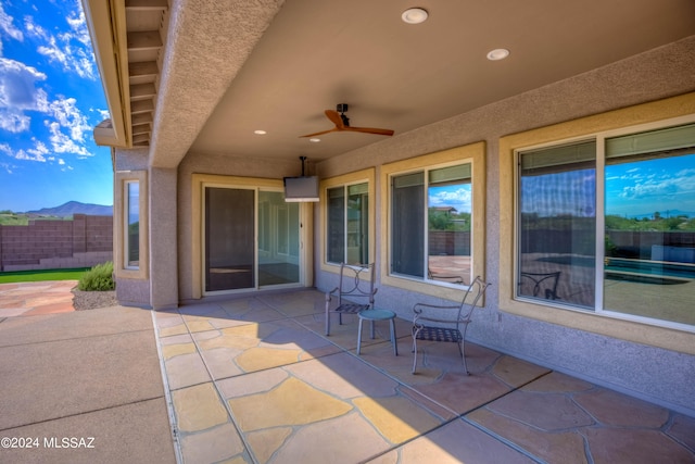 view of patio featuring ceiling fan and a mountain view