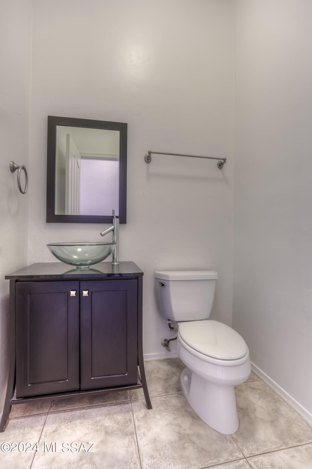 bathroom with vanity, baseboards, toilet, and tile patterned flooring