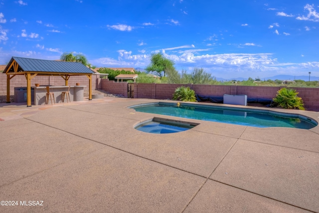 view of swimming pool with a patio, a mountain view, and an in ground hot tub