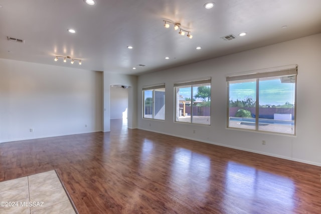 unfurnished living room with track lighting, recessed lighting, wood finished floors, and visible vents