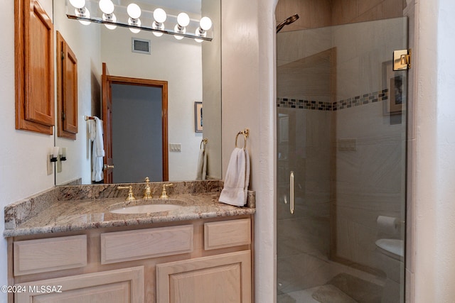 bathroom featuring vanity, toilet, and an enclosed shower