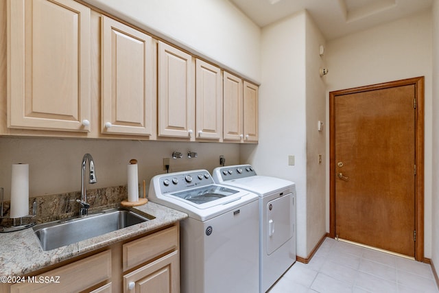 laundry area featuring washer and dryer, sink, light tile patterned floors, and cabinets