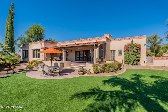 rear view of house featuring a patio, a lawn, and ceiling fan