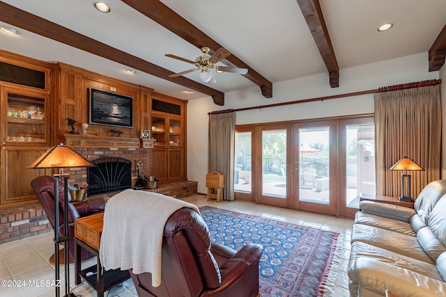 living room with ceiling fan, light tile patterned floors, a fireplace, and beam ceiling