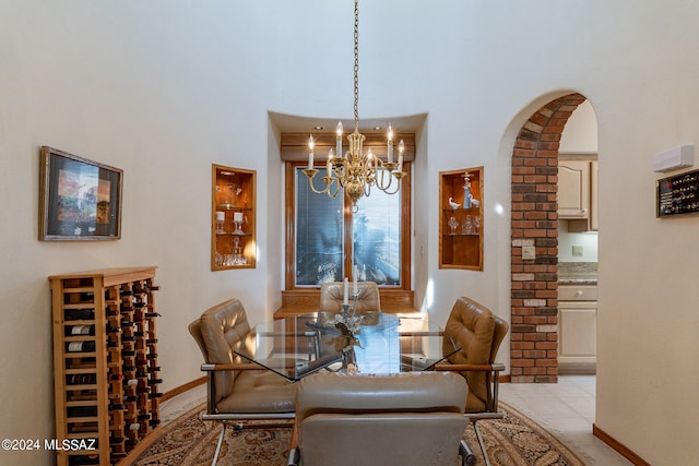 dining room featuring a notable chandelier, a towering ceiling, and light tile patterned floors