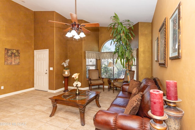 tiled living room featuring ceiling fan and a towering ceiling