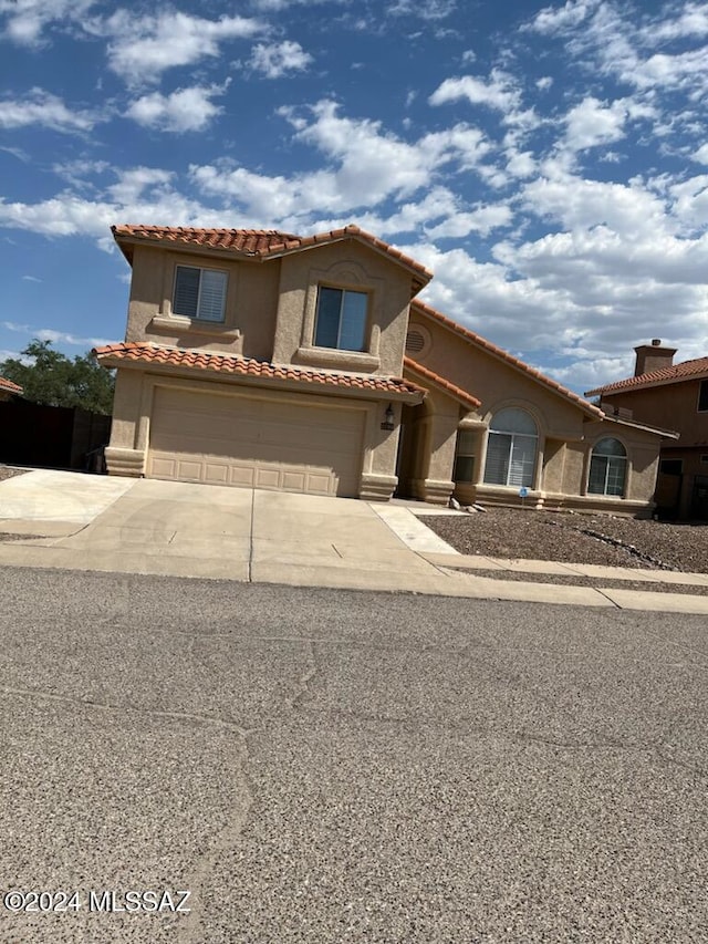 mediterranean / spanish-style home with a garage