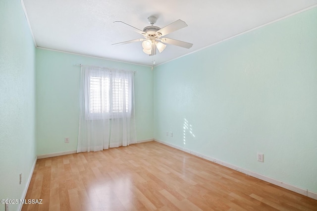 spare room featuring crown molding, ceiling fan, and light wood-type flooring