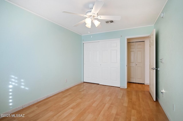 unfurnished bedroom with ceiling fan, ornamental molding, light hardwood / wood-style floors, and a closet