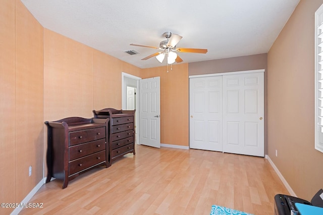 bedroom with a closet, ceiling fan, and light hardwood / wood-style flooring