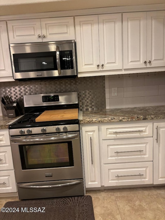 kitchen with stone counters, stainless steel appliances, decorative backsplash, and white cabinets