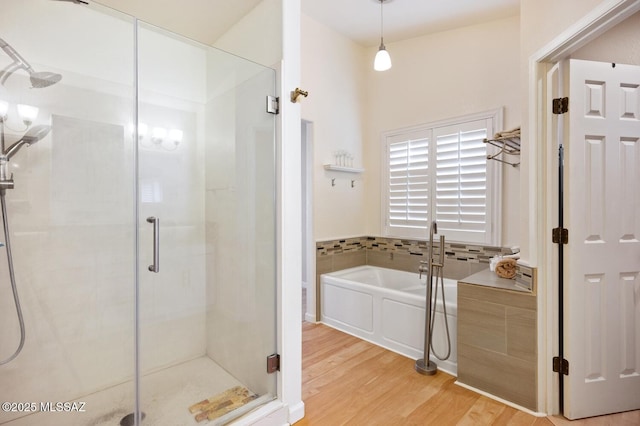 bathroom with wood-type flooring and separate shower and tub