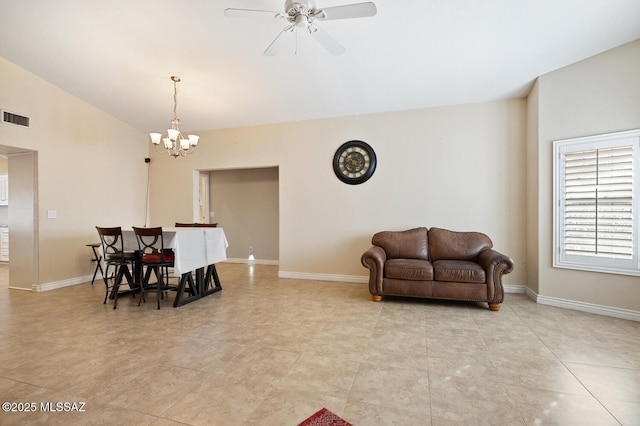 interior space with lofted ceiling, ceiling fan with notable chandelier, and light tile patterned floors