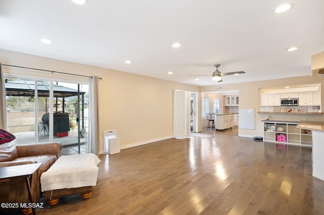 living room with ceiling fan and wood-type flooring