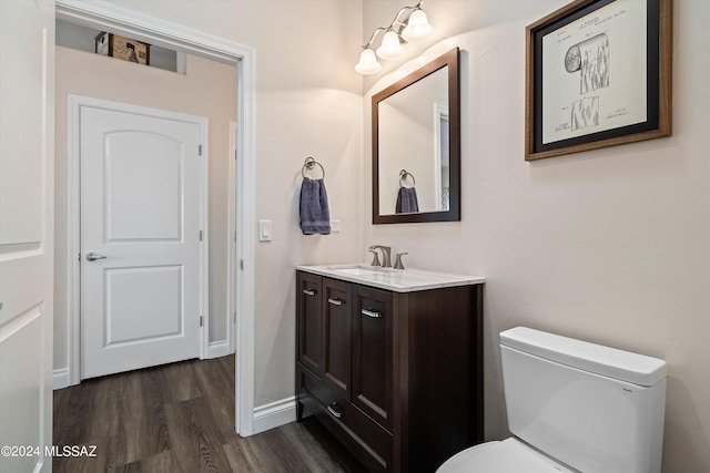 bathroom featuring wood-type flooring, vanity, and toilet