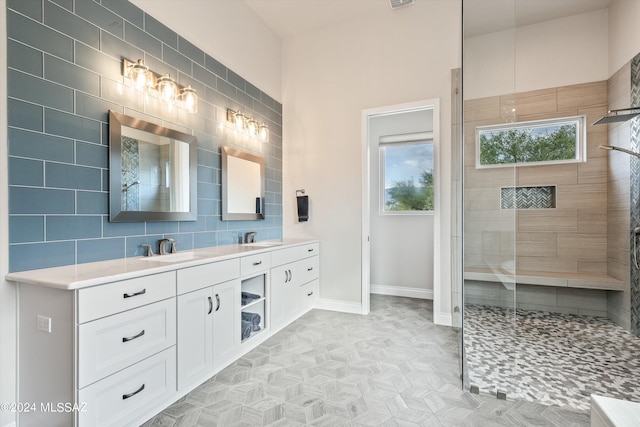 bathroom featuring vanity, decorative backsplash, a wealth of natural light, and tiled shower