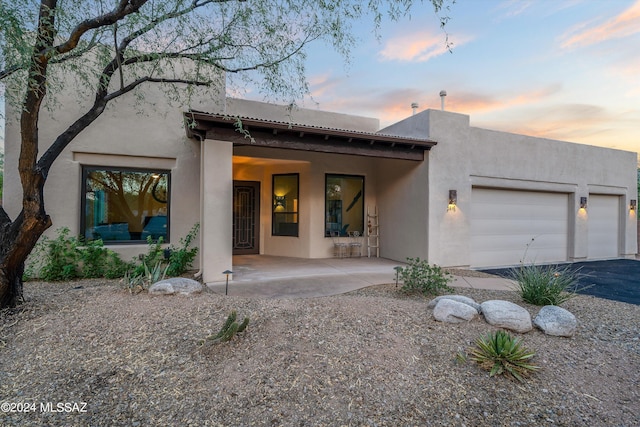 view of front of property with a garage and a patio