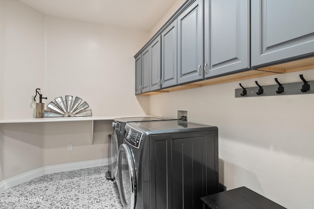 laundry area with cabinets, light tile patterned floors, and independent washer and dryer