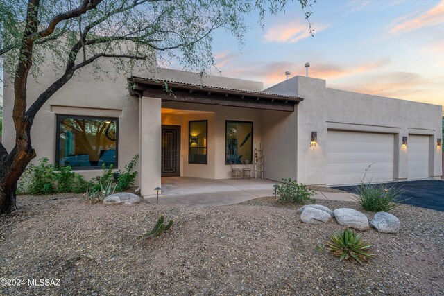 exterior entry at dusk featuring a patio