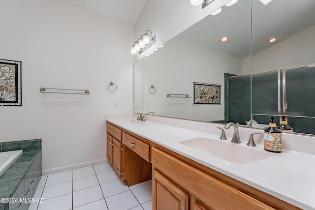 bathroom with a bathing tub, vanity, tile patterned floors, and lofted ceiling