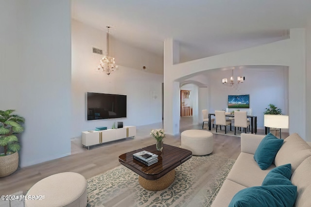 living room with a notable chandelier and light wood-type flooring