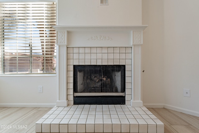 details with a tile fireplace and wood-type flooring