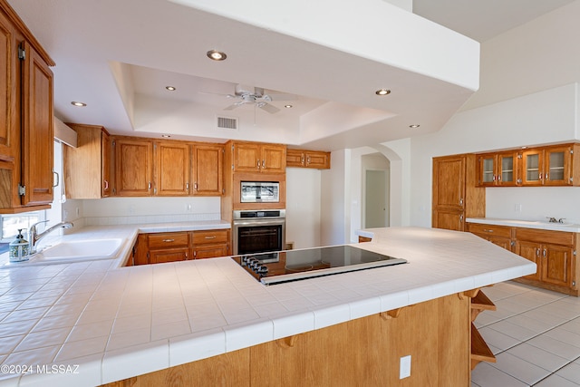 kitchen featuring kitchen peninsula, a kitchen bar, stainless steel appliances, and sink