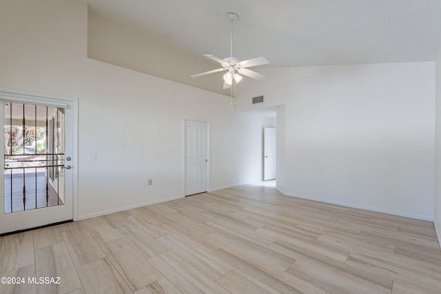 empty room with ceiling fan, light wood-type flooring, and high vaulted ceiling