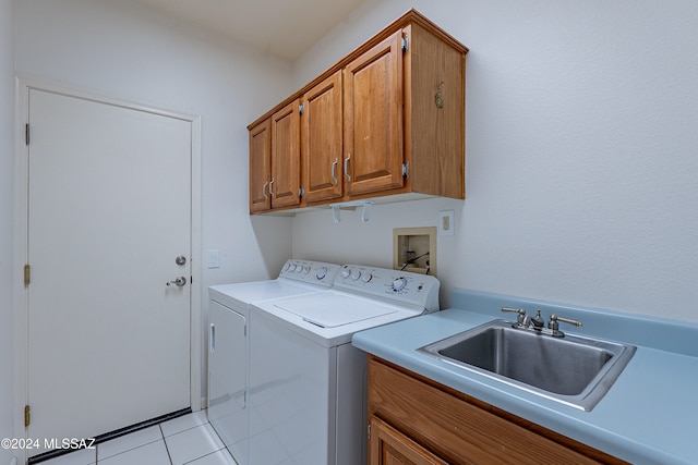 clothes washing area featuring cabinets, independent washer and dryer, light tile patterned floors, and sink