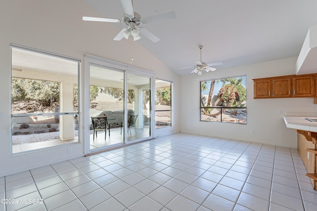 interior space featuring ceiling fan, light tile patterned floors, and high vaulted ceiling