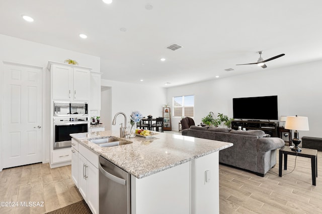 kitchen featuring white cabinets, an island with sink, stainless steel appliances, and sink