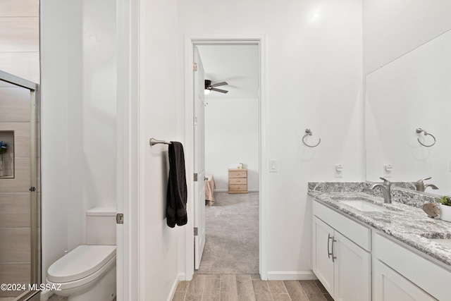 bathroom with ceiling fan, hardwood / wood-style flooring, vanity, and toilet