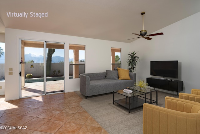 living area featuring light tile patterned floors, baseboards, ceiling fan, and lofted ceiling