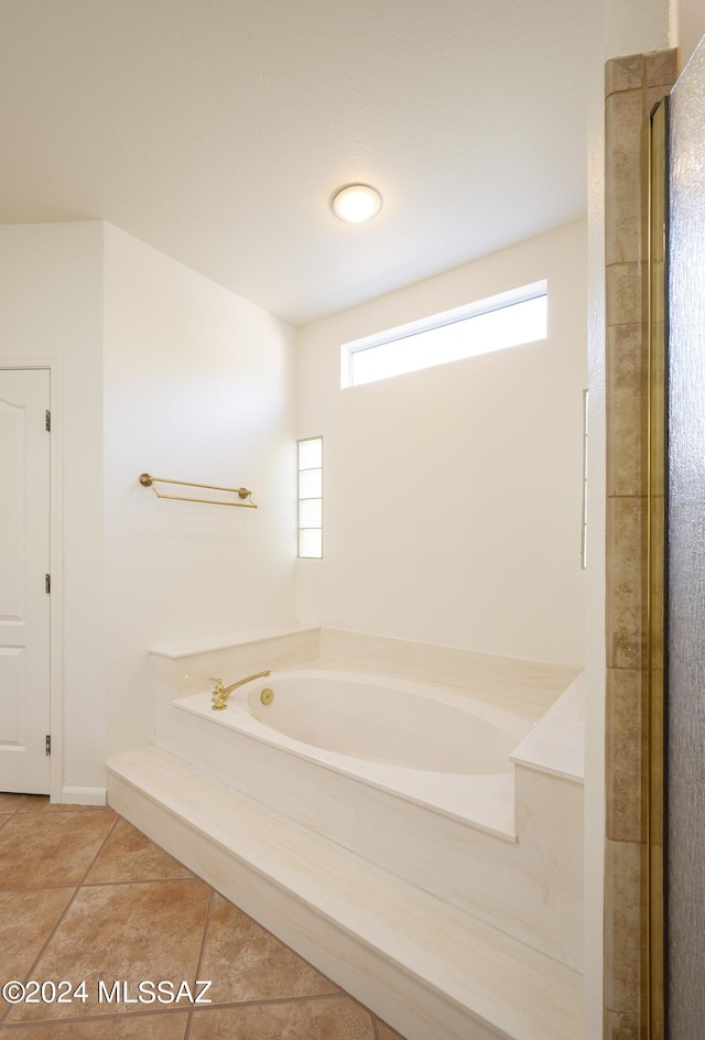 bathroom with tile patterned flooring and a garden tub