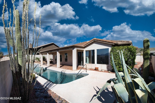 rear view of property with a fenced in pool, a patio, stucco siding, and a fenced backyard