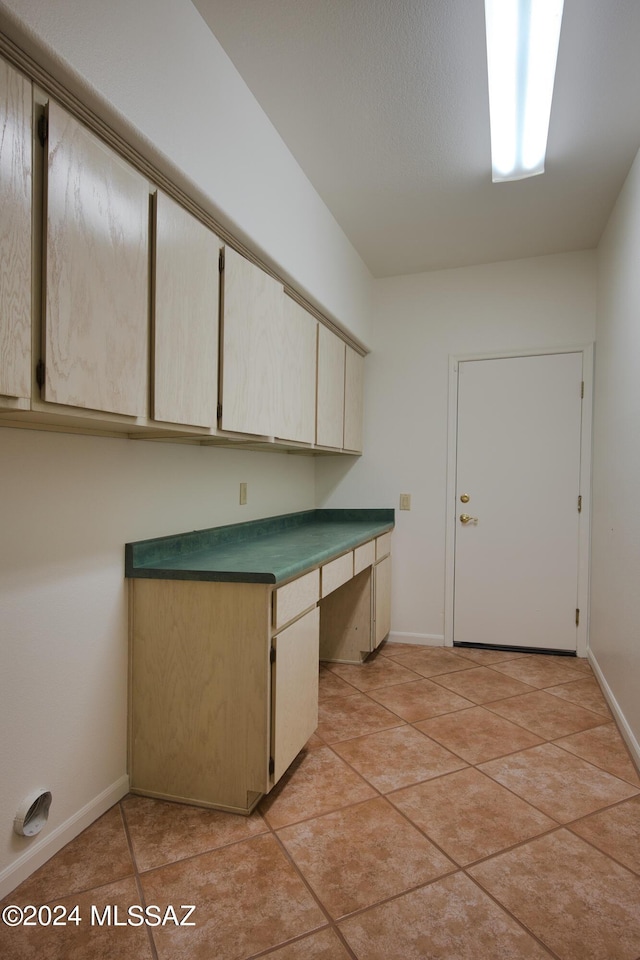 laundry area featuring baseboards and light tile patterned floors