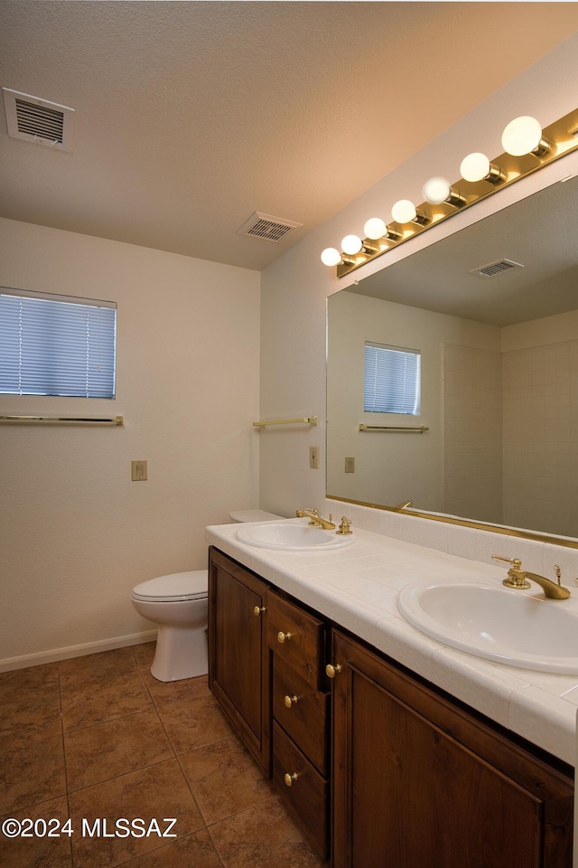 bathroom with visible vents, a sink, and double vanity