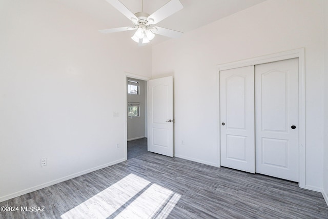 unfurnished bedroom with a closet, ceiling fan, and dark wood-type flooring