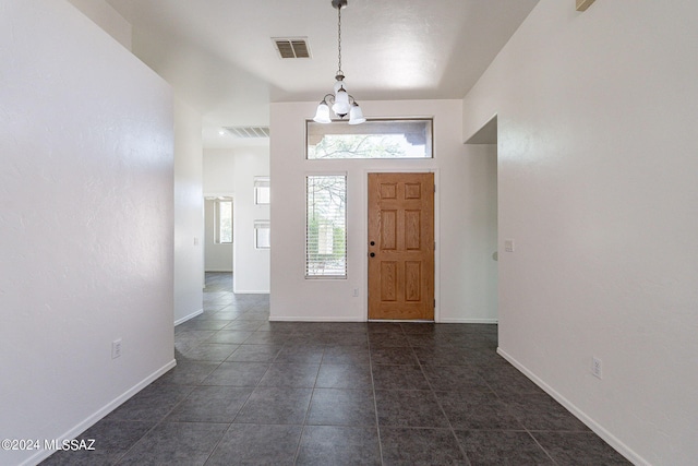 tiled entrance foyer with an inviting chandelier