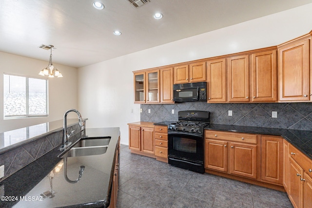 kitchen featuring hanging light fixtures, tasteful backsplash, black appliances, an inviting chandelier, and sink